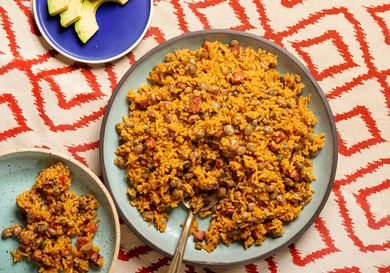 Overhead view of arroz con gandules on a red patterned background 