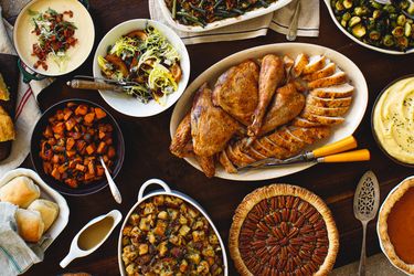 Traditional Thanksgiving dinner with roasted turkey stuffing mashed potatoes green beans and assorted side dishes and desserts