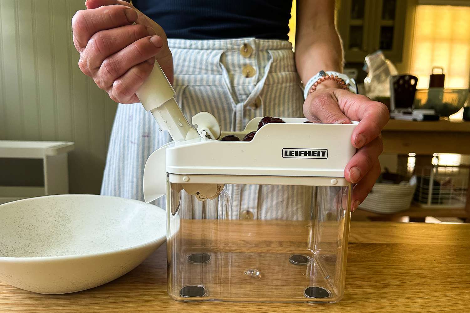 A person about to pit a cherry with the Leifheit cherry pitter