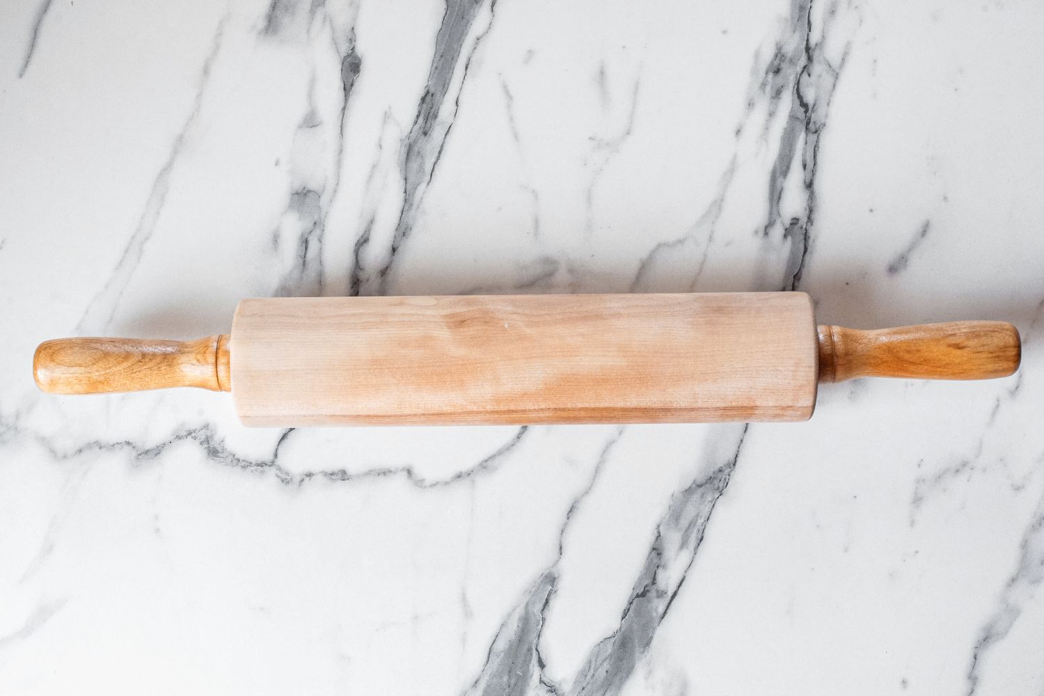 A J.K. Adams Maple Wood Medium Gourmet Rolling Pin resting on a marble surface