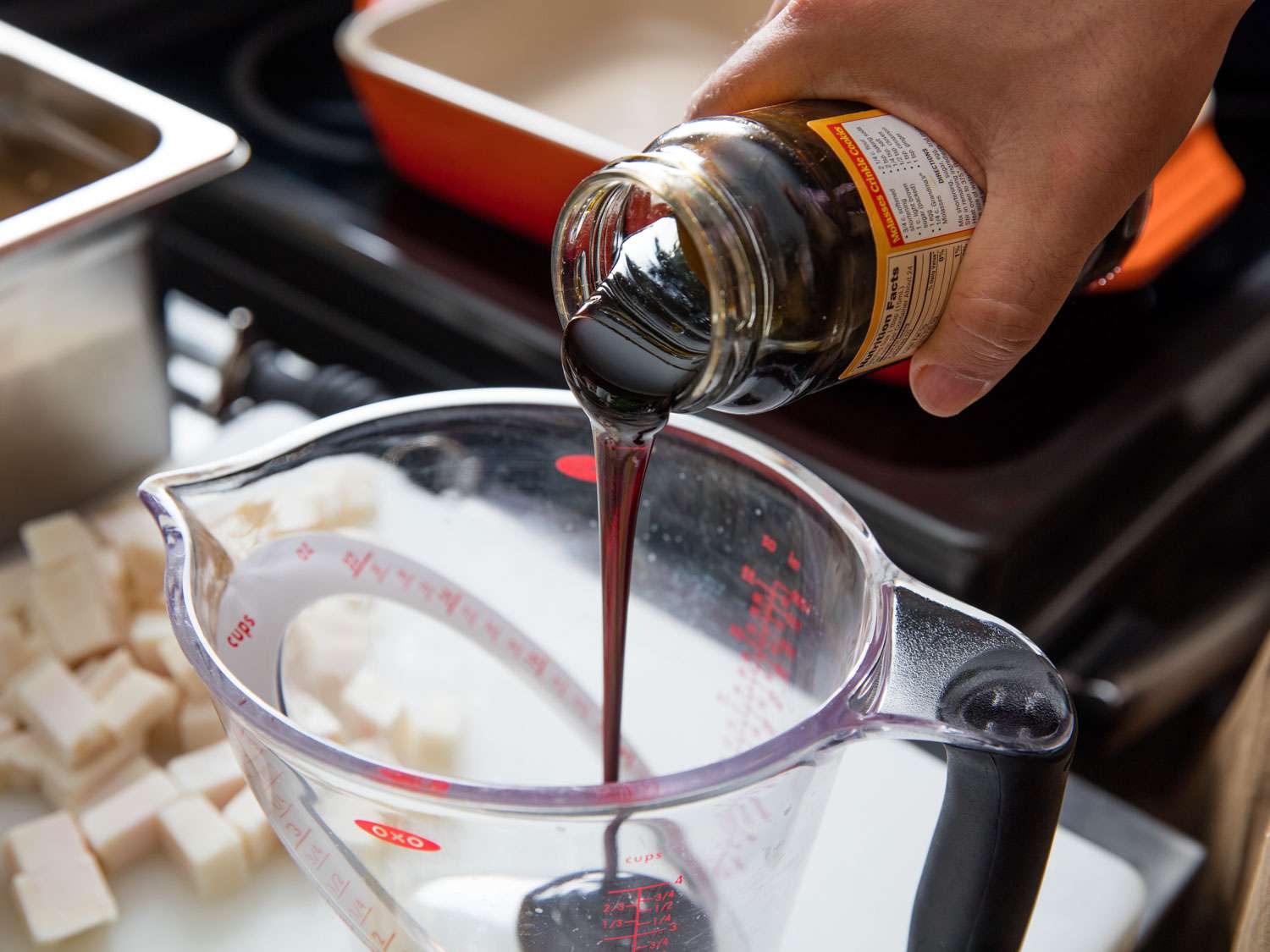 Pouring molasses into a 2-cup liquid measuring cup for Boston baked beans.