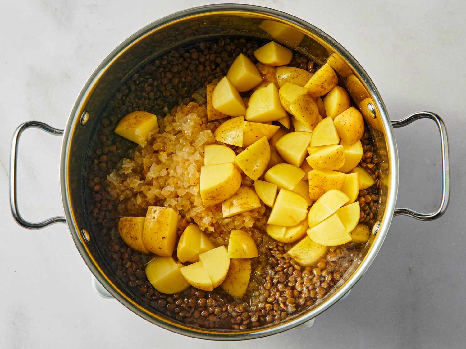 Cooking pot with lentils diced onions and potato chunks