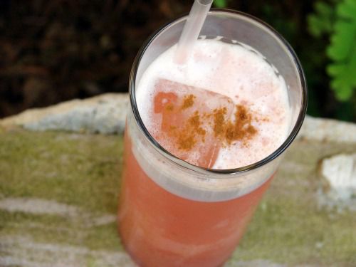 A cocktail in a highball glass with a straw. 