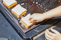 A person cooks grilled cheese on the Traeger Flatrock Flat Top Grill