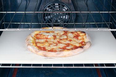 a pizza cooking on a pizza stone