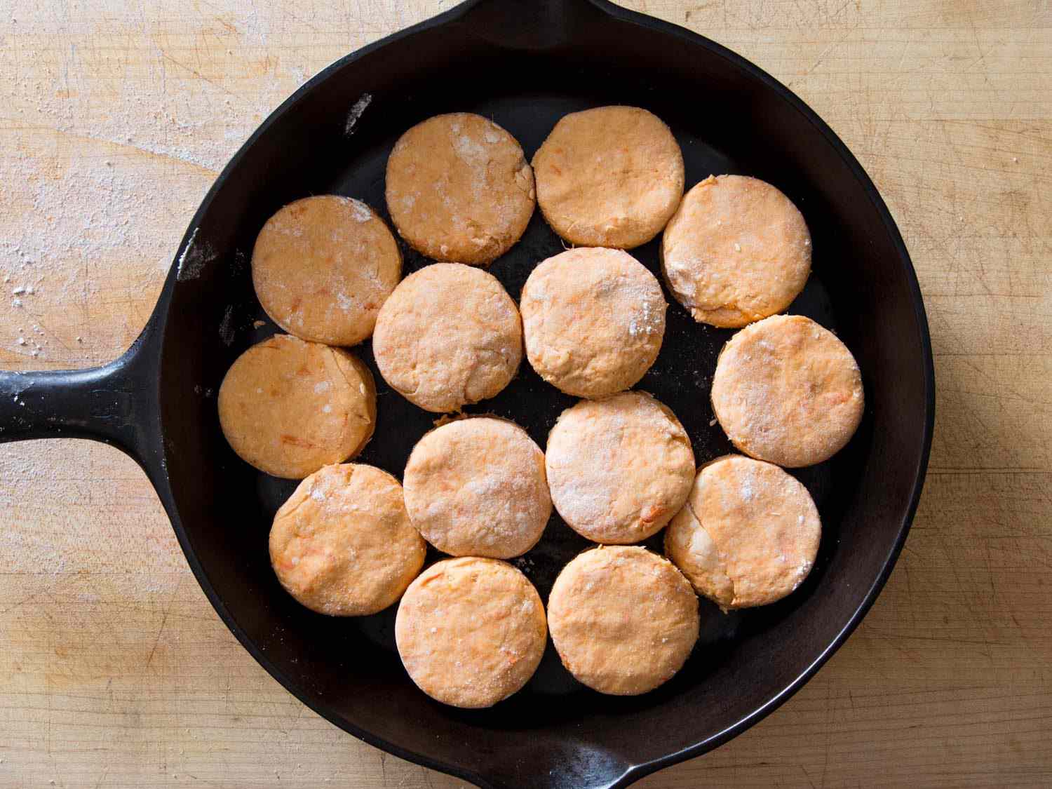 overheat shot of sweet potato dough cutouts arranged inside cast iron skillet