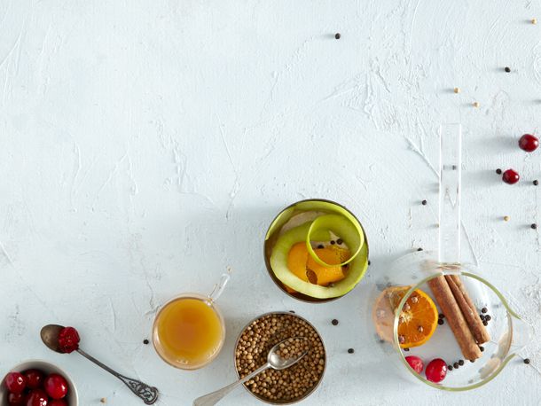 An overhead view of an Eve's addiction cocktail, surrounded by fruit and whole spices.