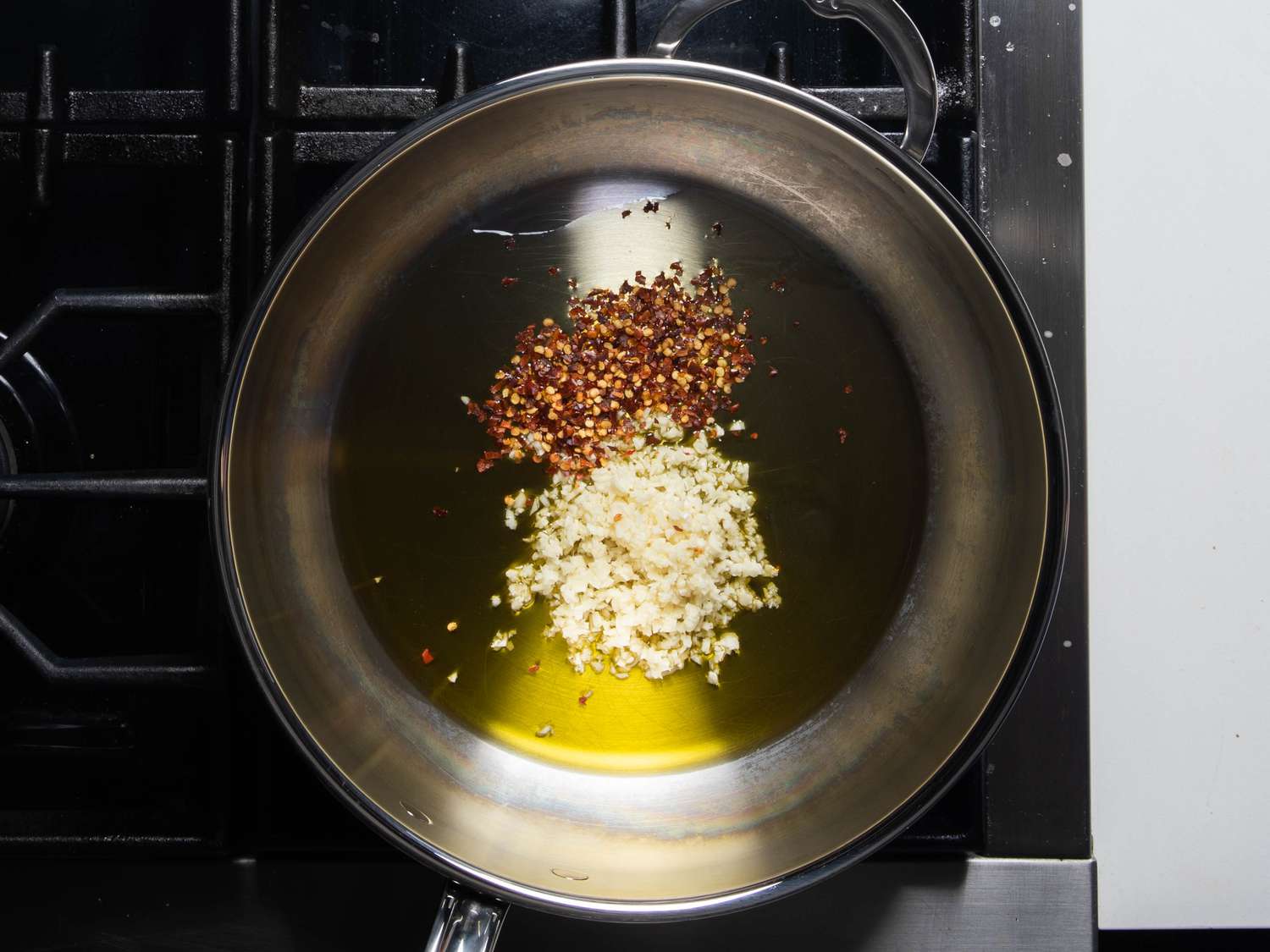 Garlic and red pepper flakes in a pan with olive oil.