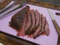 a piece of pork sliced on a purple cutting board