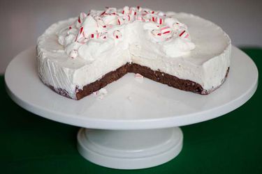A frozen black bottom peppermint pie, served on a cake stand. Several slices have been consumed.