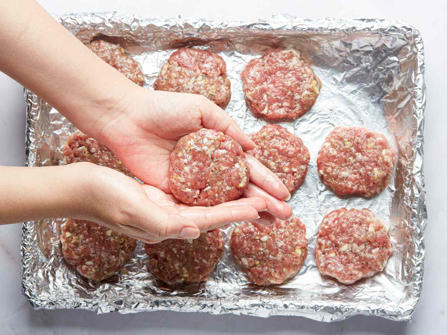 Overhead view of forming patties with oiled hands