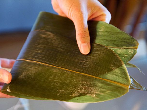Two joong leaves: edge of one leaf overlapping onto center spine of other leaf, then both leaves are folded in half. 