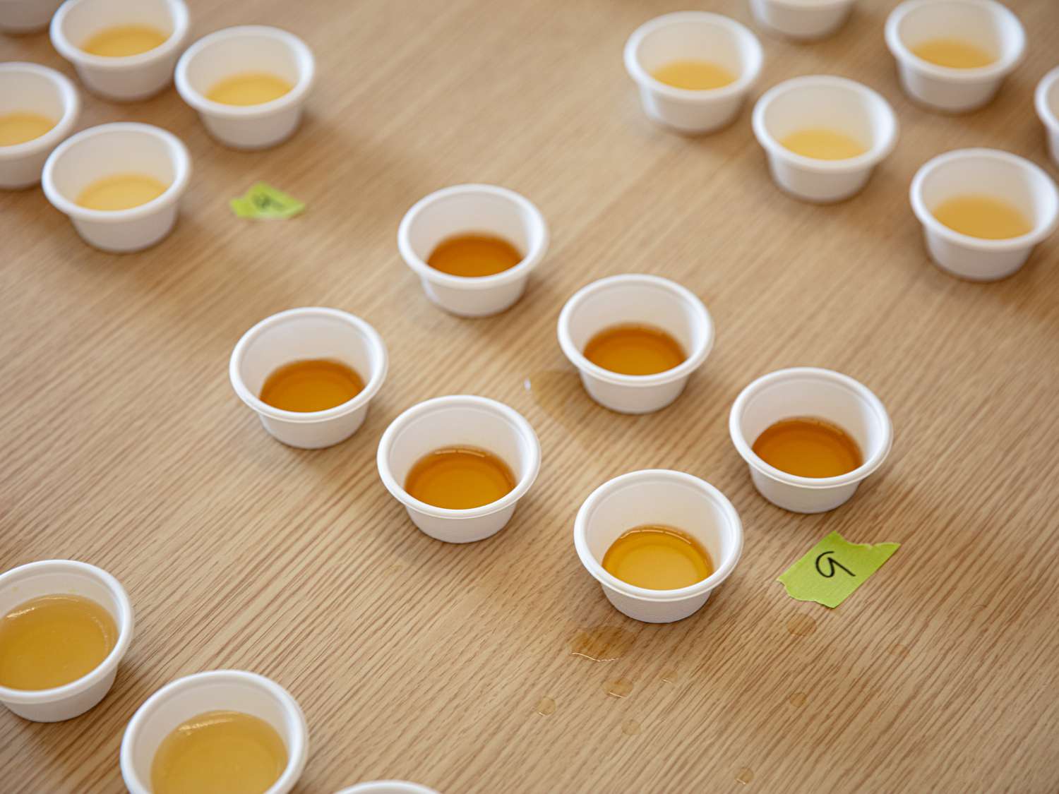 Overhead view of labeled chicken broth in tiny cups