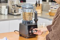 A hand turning a nob on the Vitamix Ascent X5 Blender