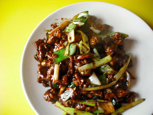 A dish of saucy Hunan lamb garnished with sauteed leeks