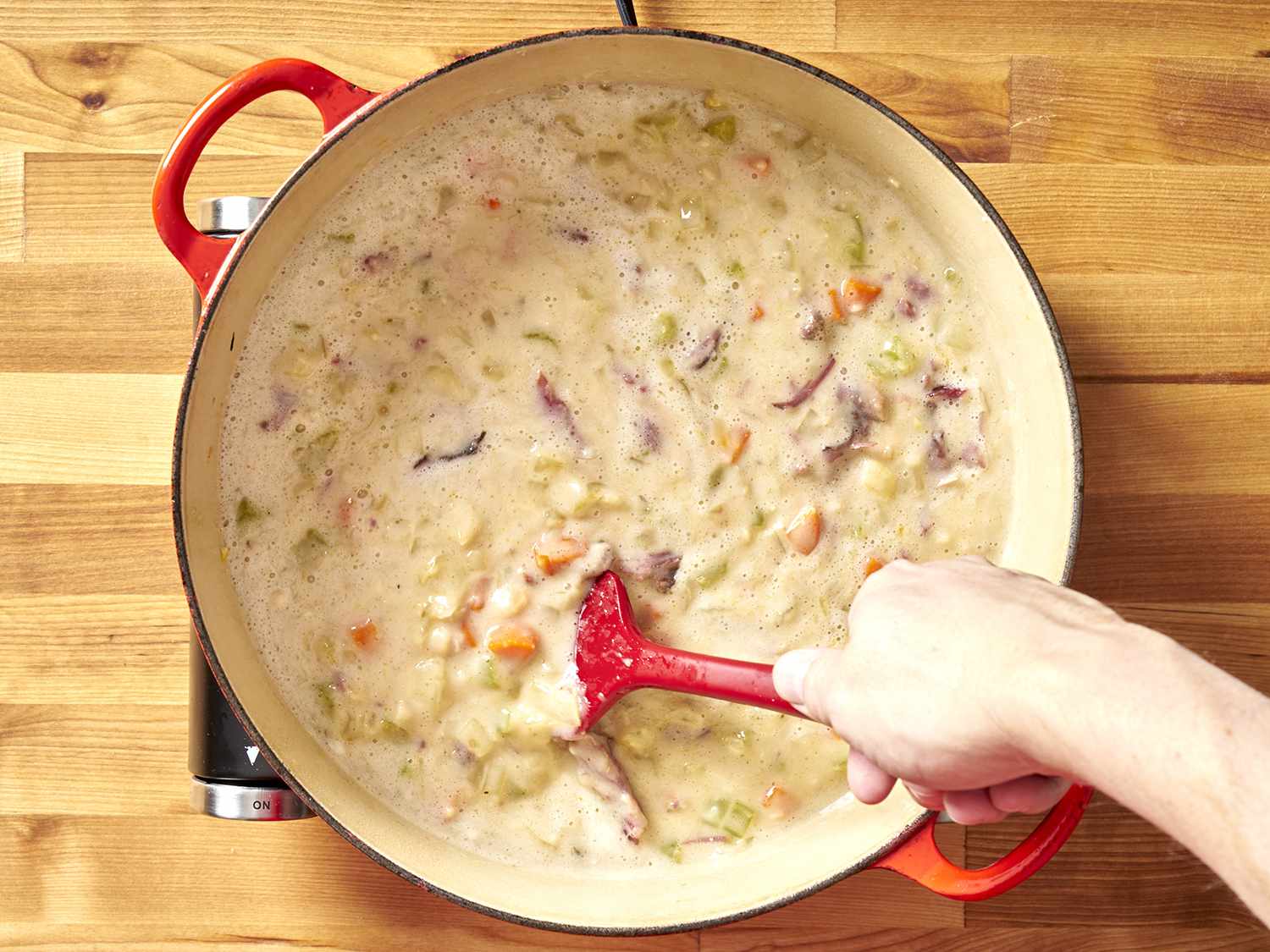 Stirring ham & bean soup to combine.