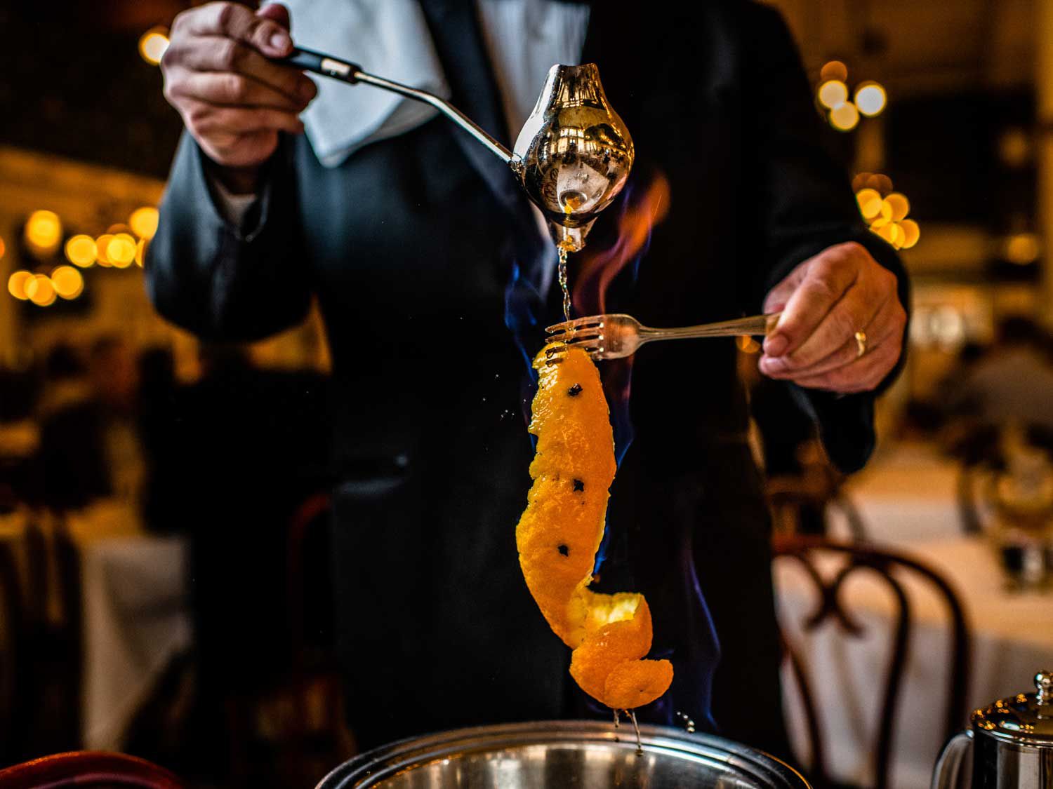 A server preparing café brulôt tableside at Galatoire's.
