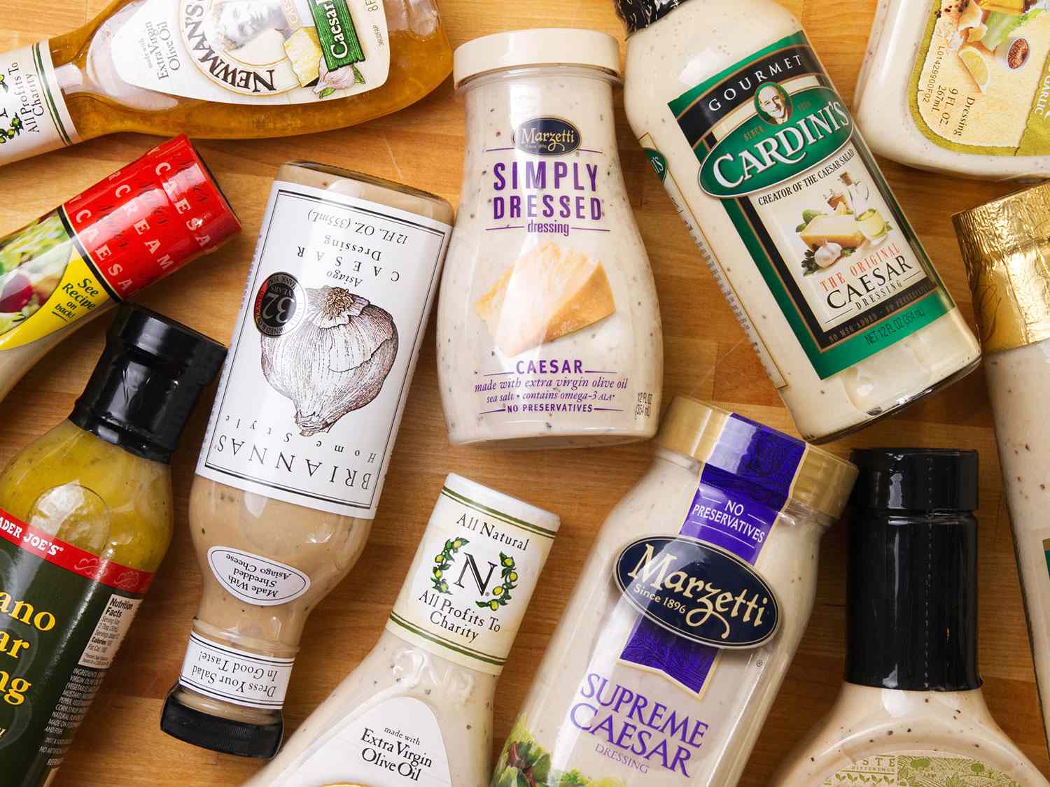 A table full of various store-bought Caesar dressings in their bottles. 