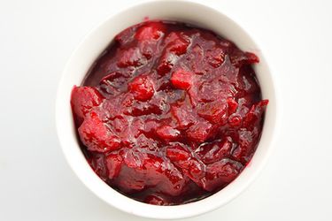 Overhead closeup of Apple-Orange Cranberry Sauce, served in a white ramekin.
