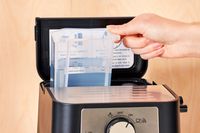 Hand holding the water reservoir of the De'Longhi Stilosa Espresso Machine