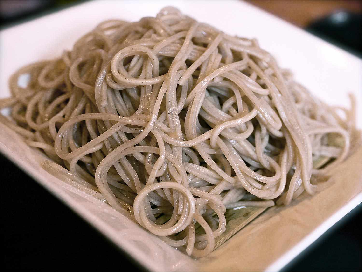 Cold soba noodles piled on a white square platter