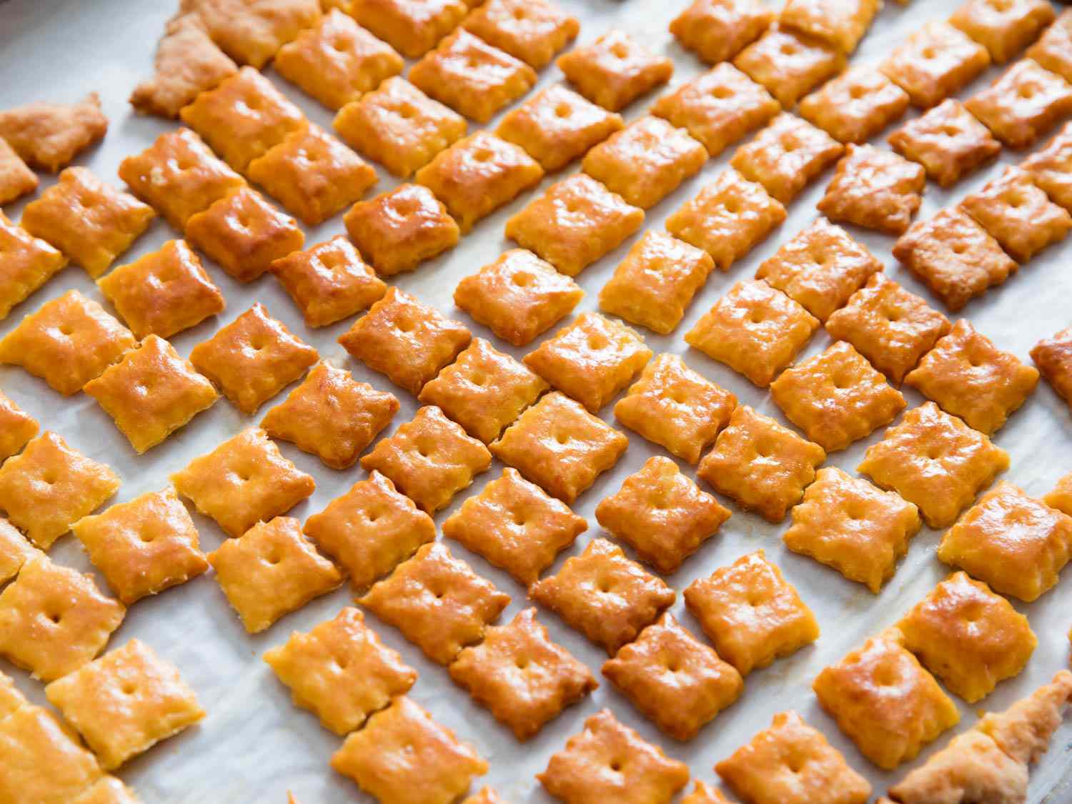 Cheez-its on a parchment-lined baking sheet, fresh from the oven.