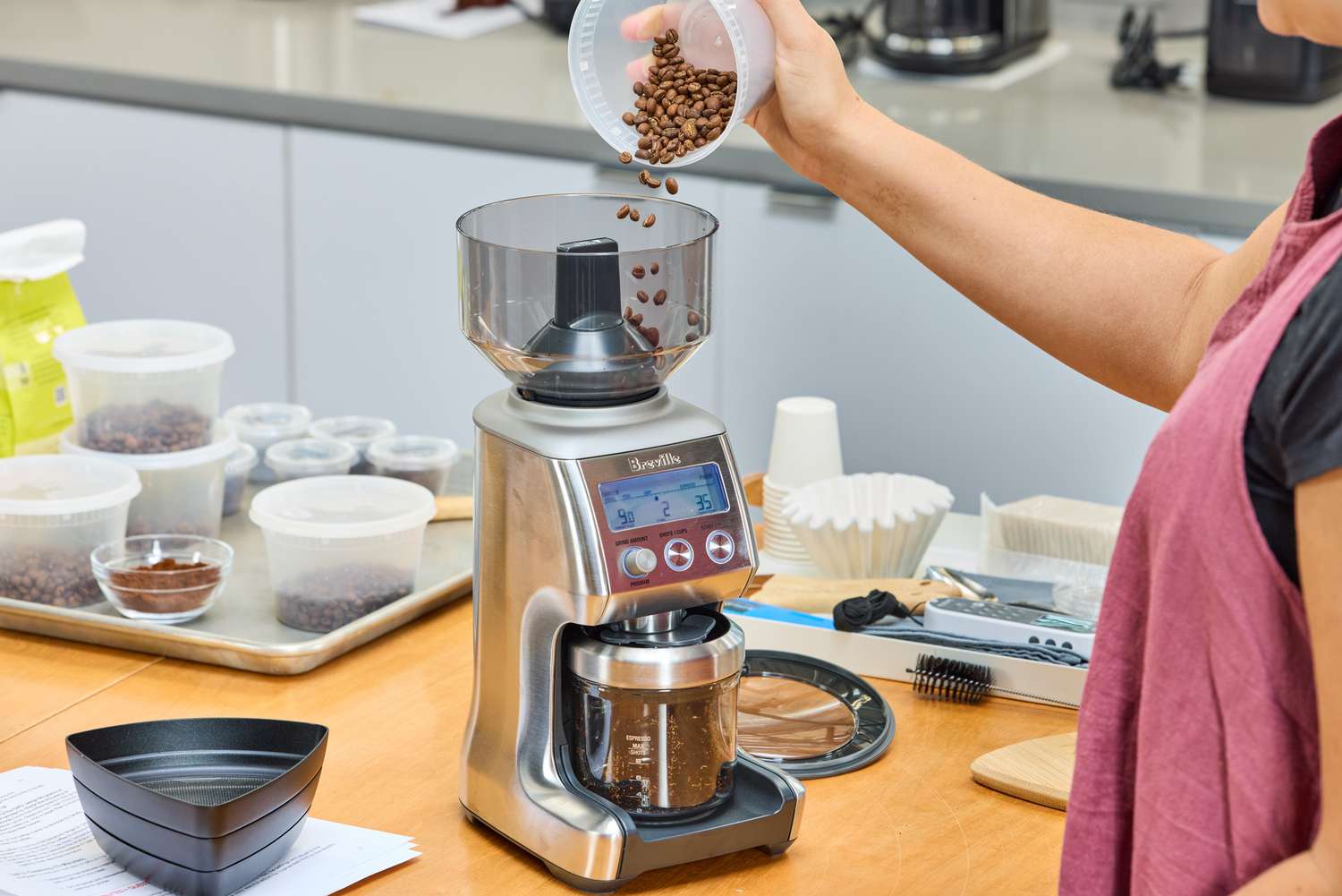 A person pours coffee beans into the Breville The Smart Grinder Pro