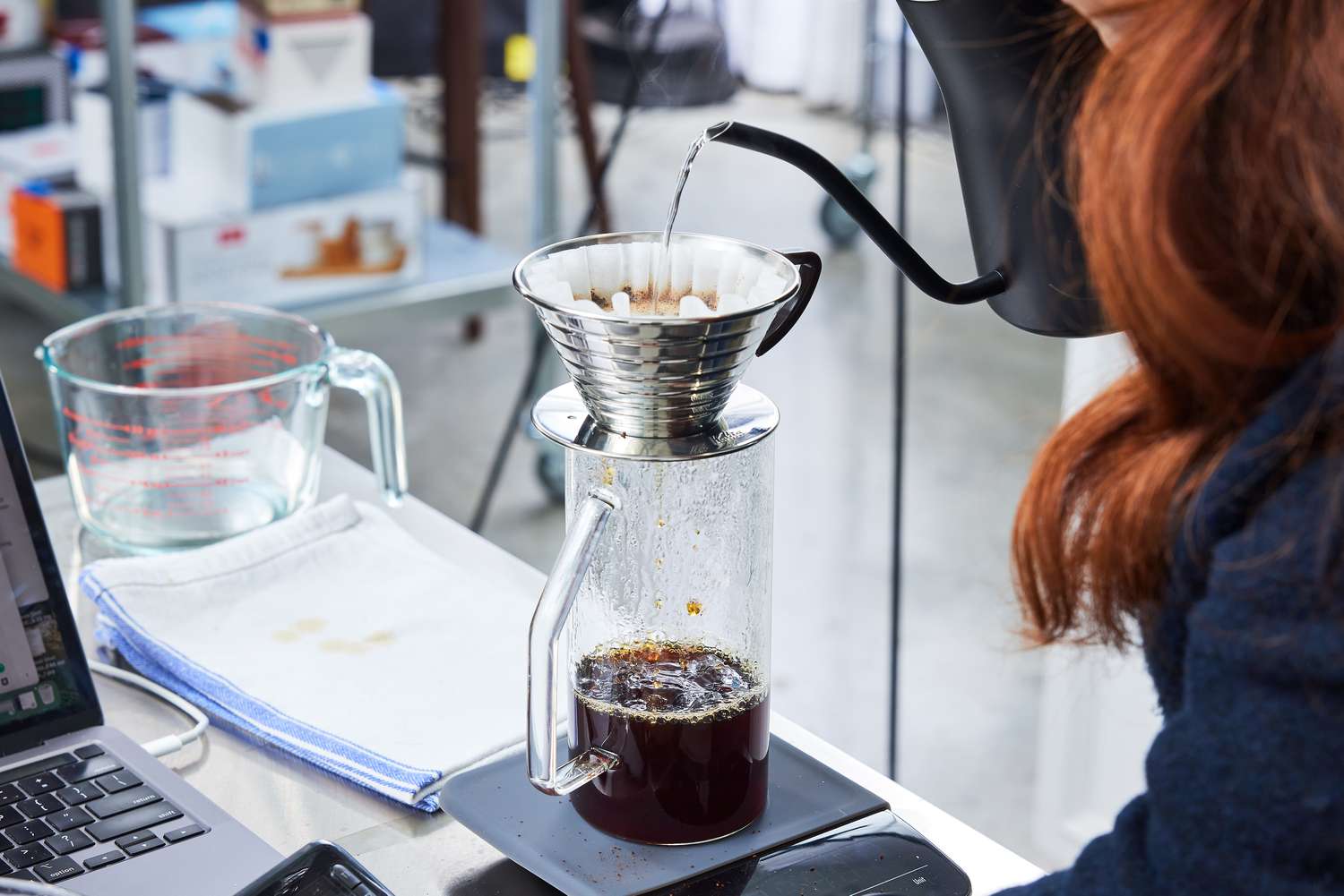 Person pouring water into a Kalita Wave 185 Dripper in a lab setting