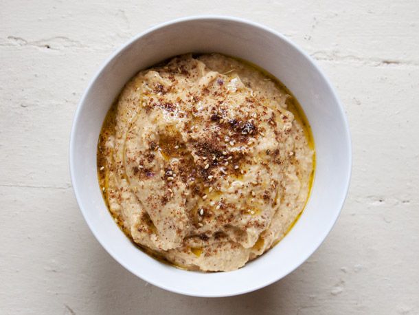Overhead shot of a bowl of Roasted Zucchini-Chickpea Dip With Za'atar, finished with olive oil.