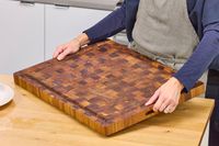 Person placing a Yes4All Teak Cutting Board on a kitchen counter