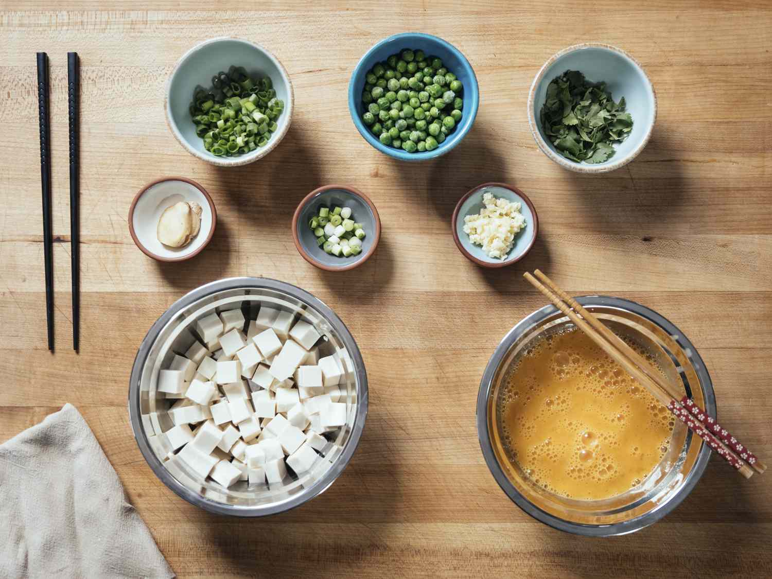 Mise en place of ingredients for Cantonese slippery eggs with tofu and peas.