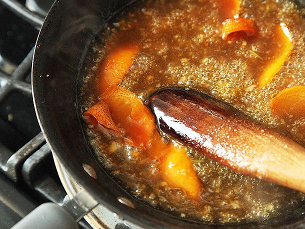 Cooking and stirring orange zest in the sauce for orange chicken.