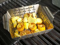 the weber grill basket with charred summer squash inside
