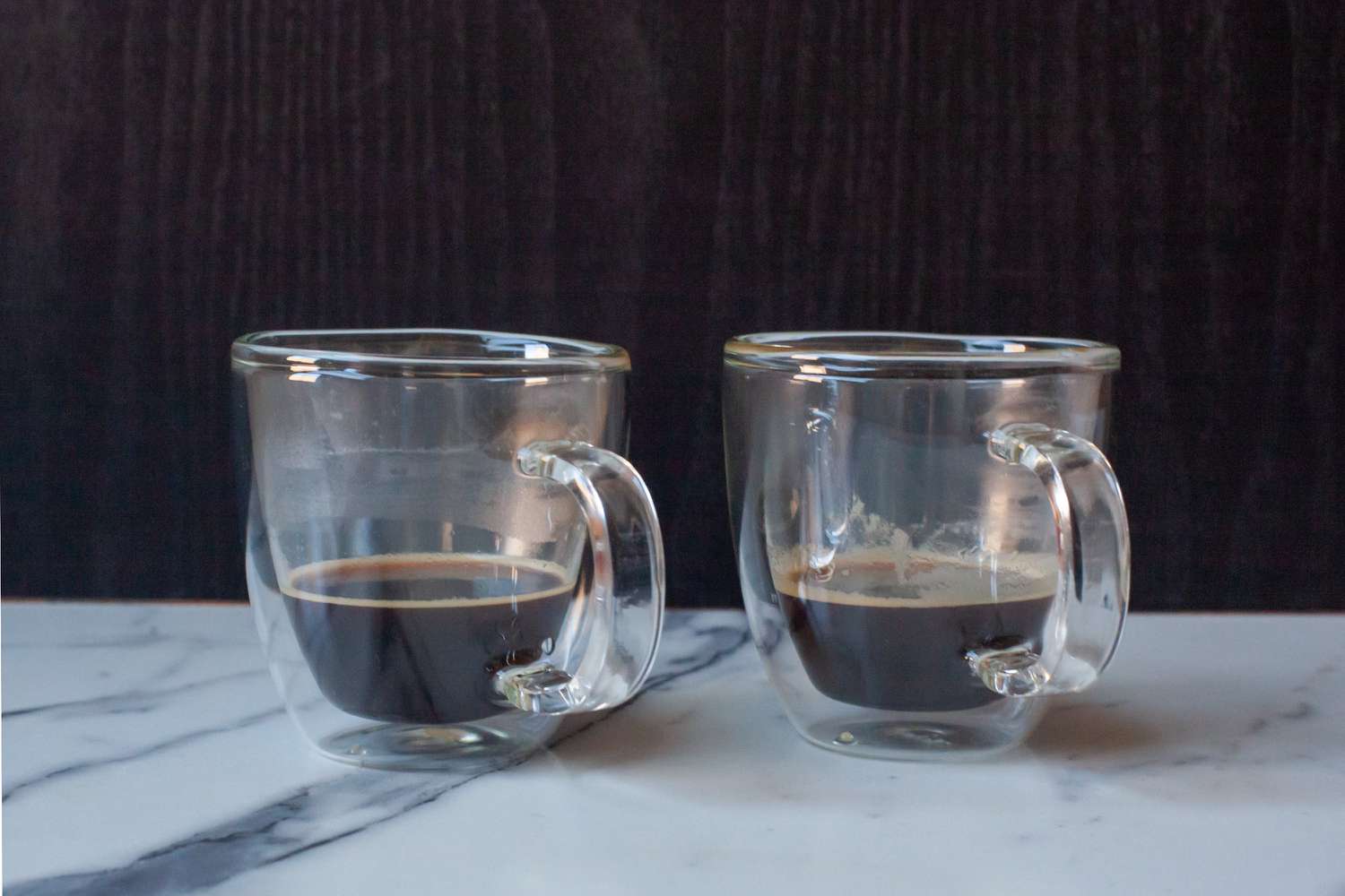 Two glass espresso cups filled with espresso.