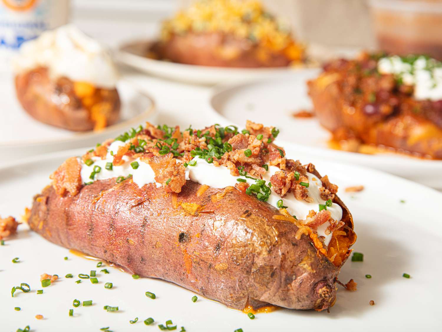 Side view of loaded backed sweet potato topped cheese and baco