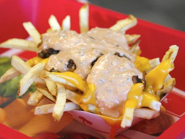 Animal Style Fries covered in cheese and sauce resting in a carton