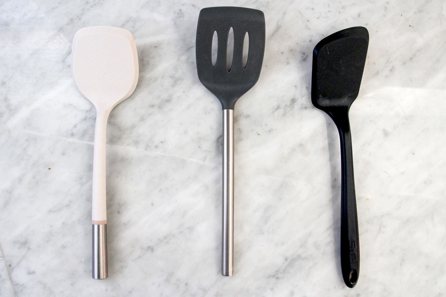 Three nonstick food turners on a marble counter