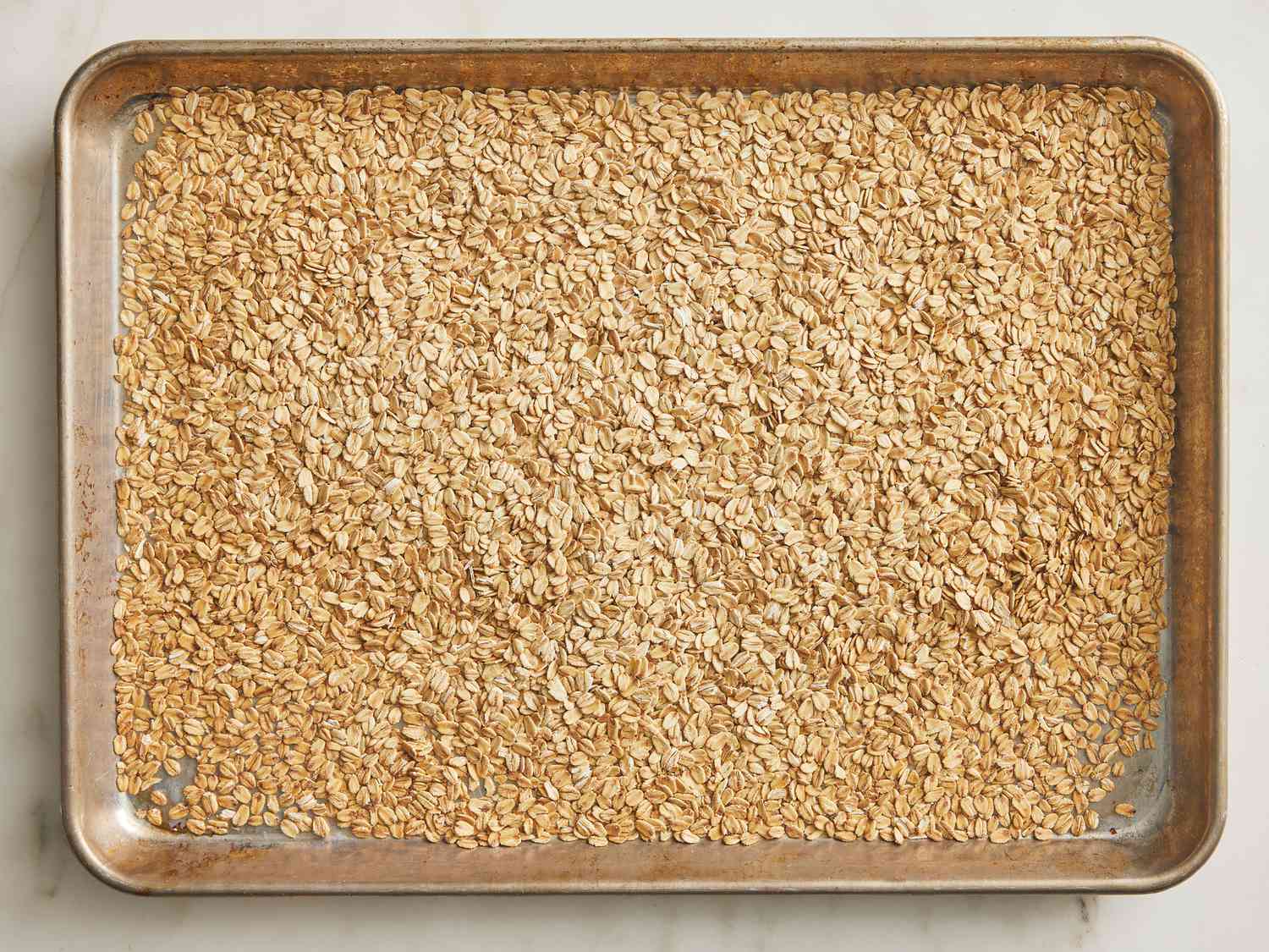 Toasted golden baked oats on a baking sheet 