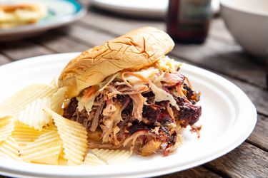 Low-and-slow pulled pork, sandwiched in a bun and served with wavy potato chips.
