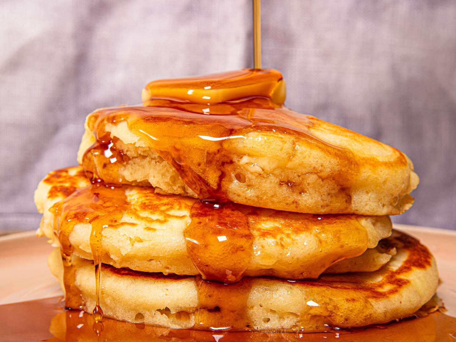 Side view of syrup being poured on pancakes