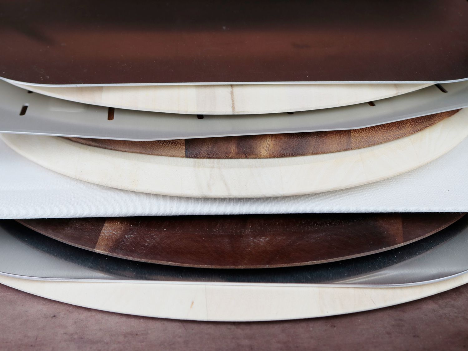 the edges of 10 pizza peels lined up 