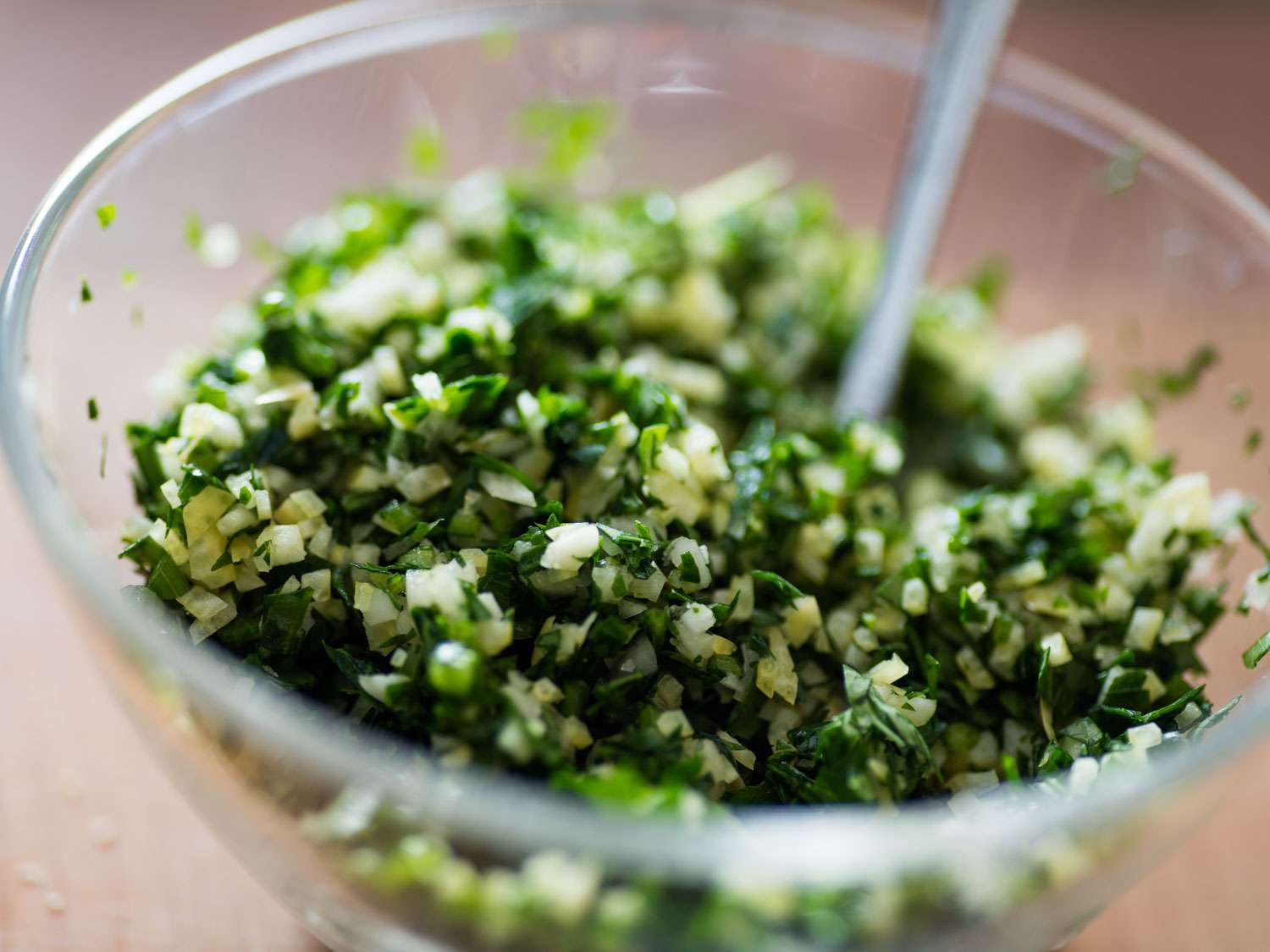 A small glass bowl of gremolata, made from parsley, garlic, and lemon zest, for topping osso buco.