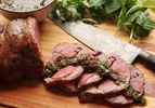 Sous vide lamb leg sliced up topped with chimichurri sauce 