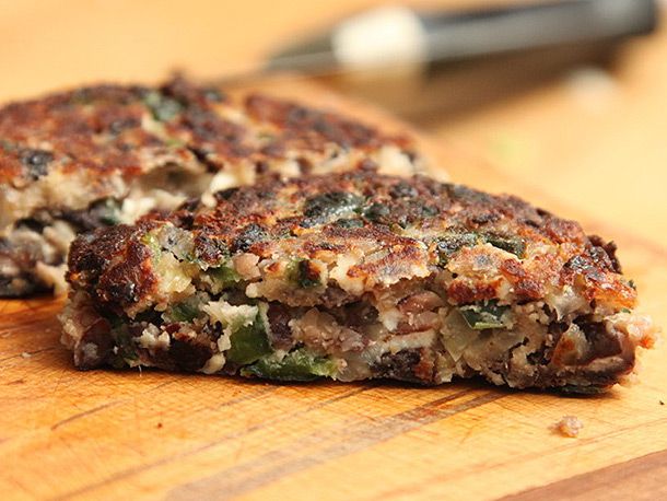 Cross-section of black bean burger with feta and cashews.