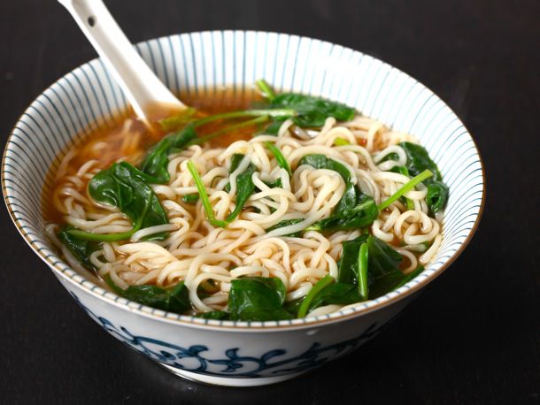 A bowl of ramen with fresh spinach wilted in.