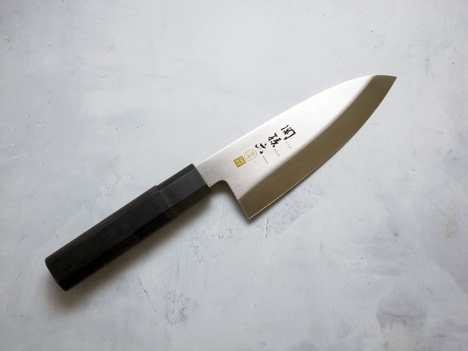 kai seki deba knife on a grey concrete backdrop