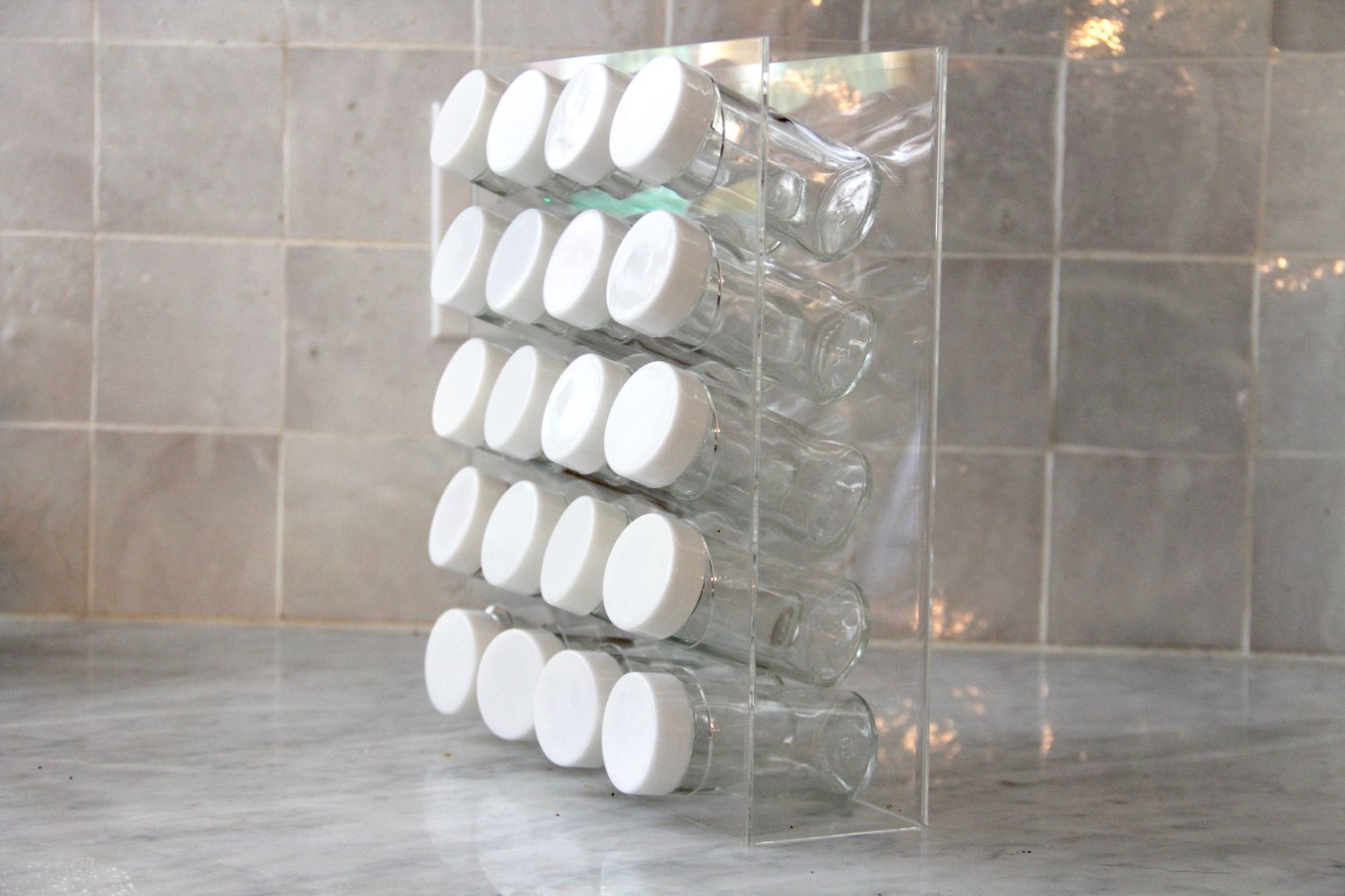 an acrylic spice rack with empty spice botles 