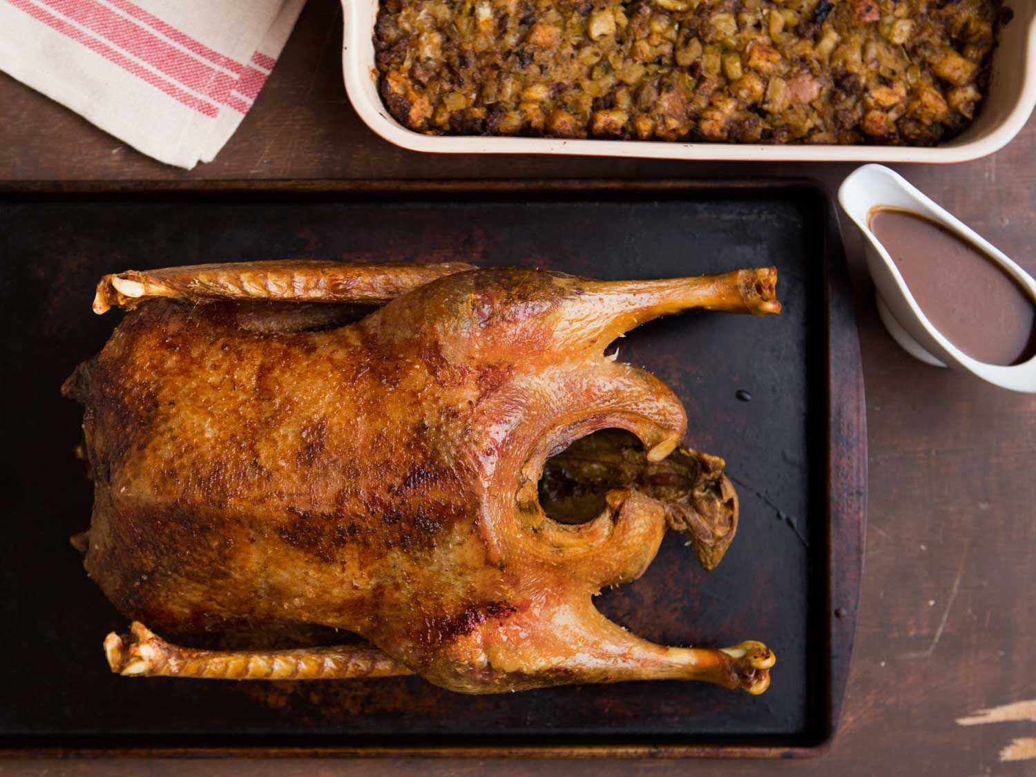 Overhead photo of roast goose next to tray of stuffing.