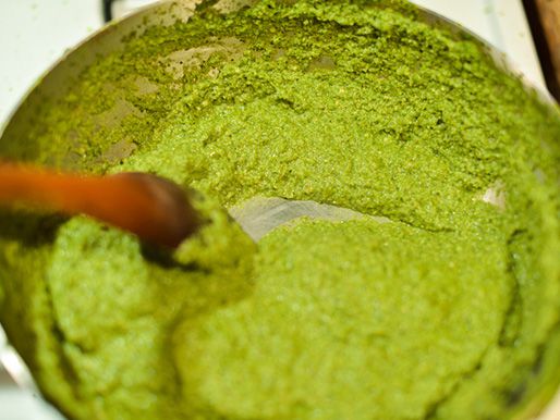 Green mole is cooked and thickened in a saucepan.