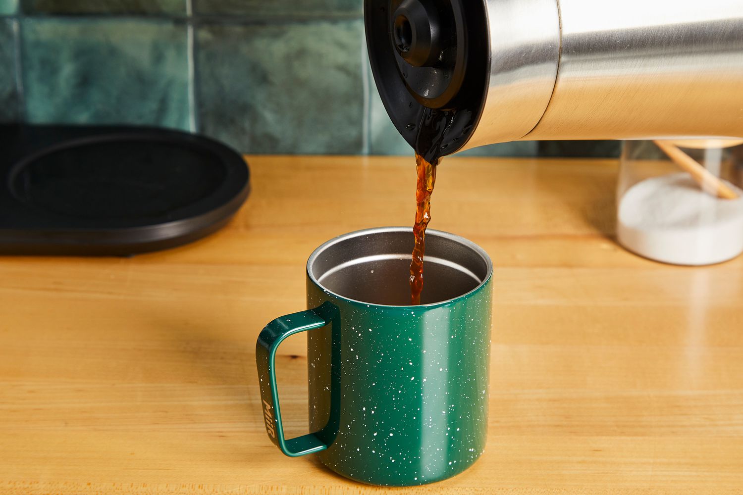Coffee being poured into a MiiR travel cup.